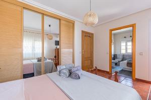 a bedroom with a bed and a living room at Villa Cristina con piscina privada y BBQ in Carranque