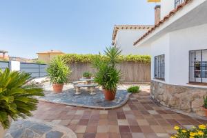 a patio with potted plants and a table at Villa Cristina con piscina privada y BBQ in Carranque