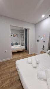 a white bedroom with a bed and a mirror at Villa Verde in Madrid
