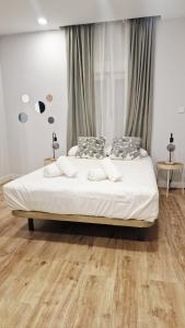 a bedroom with a bed with white sheets and pillows at Villa Verde in Madrid