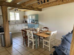 a kitchen with a table and chairs in a room at Le Gîte de Julia in Saint-Laurent-de-Médoc +3 photos