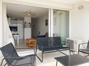 ein Wohnzimmer mit Stühlen und einem Tisch in der Unterkunft Carnon vue Port in Mauguio