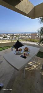 a white table with a plate of food on it at Bizerte Résidence soltana RDC vue mer in Bizerte