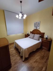 a bedroom with a white bed and two night stands at Apartamento la Costa in Colunga
