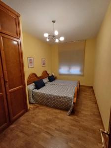 a bedroom with a bed with blue pillows on it at Apartamento la Costa in Colunga