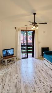 a living room with a ceiling fan and a flat screen tv at Depto con cochera, súper ubicación! in Pinamar