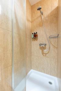 una ducha con puerta de cristal en un baño en El Poris, en Porís de Abona