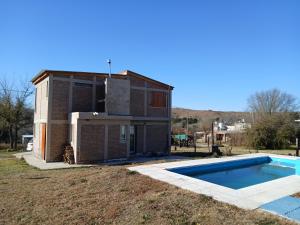 a house with a swimming pool in front of it at Remanso in La Estancia