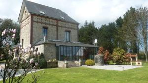 a large brick house with a large window at La maison des musiciens in Digosville