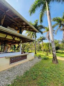 a building with a palm tree next to a park at Eco Lodge near Corcovado, 400m to Beach on a Peaceful Private Reserve in Agujas