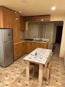 a kitchen with a table and a refrigerator at Friends & Family II in Yerevan