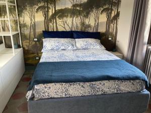a bedroom with a bed with a blue comforter at Il Boschetto - Vista Lago in Montorfano