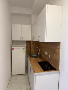 a kitchen with white cabinets and a sink and a refrigerator at D&M Apartments in Struga +13 photos