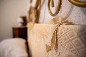 a close up of a bed with a bow on it at ISLAND VIBES ROOMS, Su Salighe in Torralba