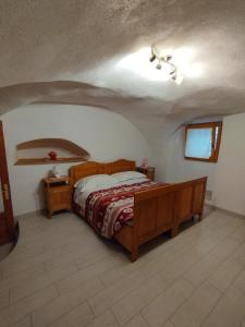 une chambre avec un lit en bois dans une pièce dans l'établissement Alloggio Turistico LA VECIA DEL BORGO, à Dorsino