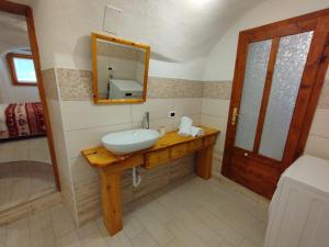 une salle de bain avec un lavabo et un miroir dans l'établissement Alloggio Turistico LA VECIA DEL BORGO, à Dorsino 10 autres photos