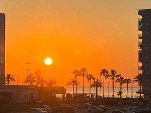 a sunset over a parking lot with palm trees at Casa Voramar in Cullera