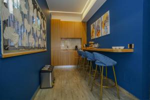 a bar with blue walls and stools in a room at La Scogliera In in Aci Castello