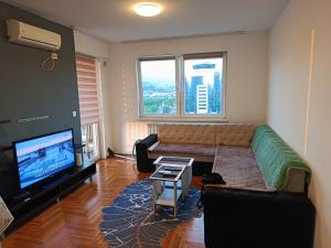 Una sala de estar con un sofá y un televisor de pantalla plana. en Luxury NEOM apartment, STUP, Sarajevo, en Sarajevo