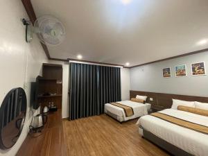 Una habitación de hotel con dos camas y un ventilador. en A&E hotel2, en Qua Phố