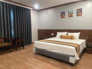 Un dormitorio con una cama y un escritorio y una ventana. en A&E hotel2, en Qua Phố