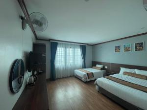 Una habitación de hotel con dos camas y un televisor. en A&E hotel2, en Qua Phố