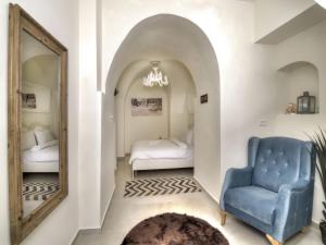 a bedroom with a mirror and a blue chair at הבית בעתיקה in Safed