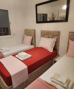 a small room with two beds and a mirror at Bouchra in Martil +3 photos