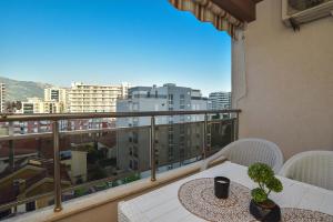 a balcony with a table and chairs and a view of a city at Omega 2 Apartment Budva in Budva