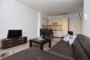 a living room with a couch and a tv and a table at Omega 2 Apartment Budva in Budva