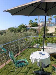 a patio with a table and chairs and an umbrella at "Spyros" 1-Room Apartment - Simple, cozy, close to the beach in Kato Daratso