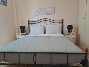 a bedroom with a large bed with two night stands at Spacious apartment with view and garden for kids! in Tinos Town