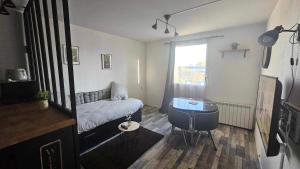a small living room with a couch and a window at Appartement proche Futuroscope in Chasseneuil-du-Poitou