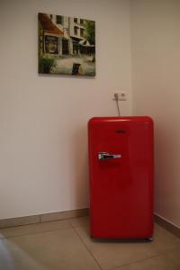 a red refrigerator in a room with a painting at Felsenblick in Pforzheim