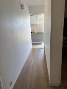 ein leerer Raum mit Küche und Holzboden in der Unterkunft Chambre à 20 minutes de Paris NOTRE DAME, APPARTEMENT COMMUN in Épinay-sur-Seine