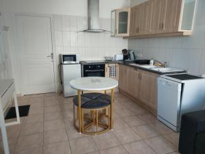 eine kleine Küche mit Tisch und Spüle in der Unterkunft petite maison lavardac in Lavardac
