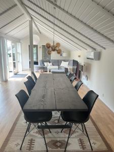 a dining room table with chairs and a living room at Cozy holiday home - spa, hot tub and play room - close to Marielyst square in Marielyst