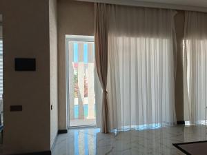 a room with a large window with white curtains at White House - Stylish Villa with Pool in Baku