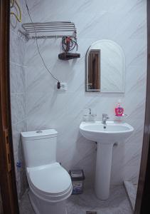 a bathroom with a white toilet and a sink at SAIDA Family Guest House in Samarkand +25 photos