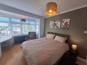 a bedroom with a bed and a chair and a window at Elegant Home SW16 Near Station Views Flexible Beds in Streatham Vale