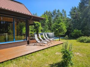 a group of chairs sitting on a wooden deck at Leśne Wspomnienia in Niesiołowice