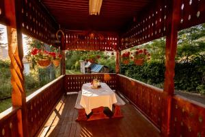 a wooden porch with a table and flowers on it at Casa Izvoru Mureșului in Izvoru Mureşului