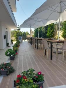 a patio with tables and chairs and umbrellas at Vila Ervin Second Floor in Ksamil +2 photos