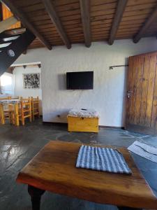 Una habitación con una mesa y un televisor de pantalla plana. en Paseo Iñaki, en Lago Puelo