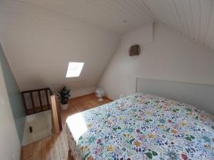 a bedroom with a bed with a floral comforter at Entre temps et pavés in Huy