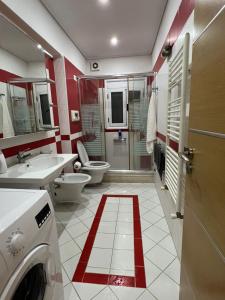 a bathroom with a toilet and a sink and a washing machine at Vila Oron in Vlorë