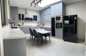 a kitchen with a table and black appliances at فيلا ابها 3 in Abha