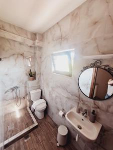 a bathroom with a sink and a toilet and a mirror at Anastasia Chalatsogianni Rooms in Paralia Panteleimonos +29 photos