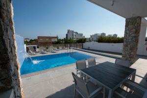 a patio with a table and chairs and a swimming pool at Theo luxury Napa villa in Ayia Napa
