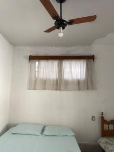 a bedroom with a ceiling fan and a window at Casa Couto Magalhães in Anápolis